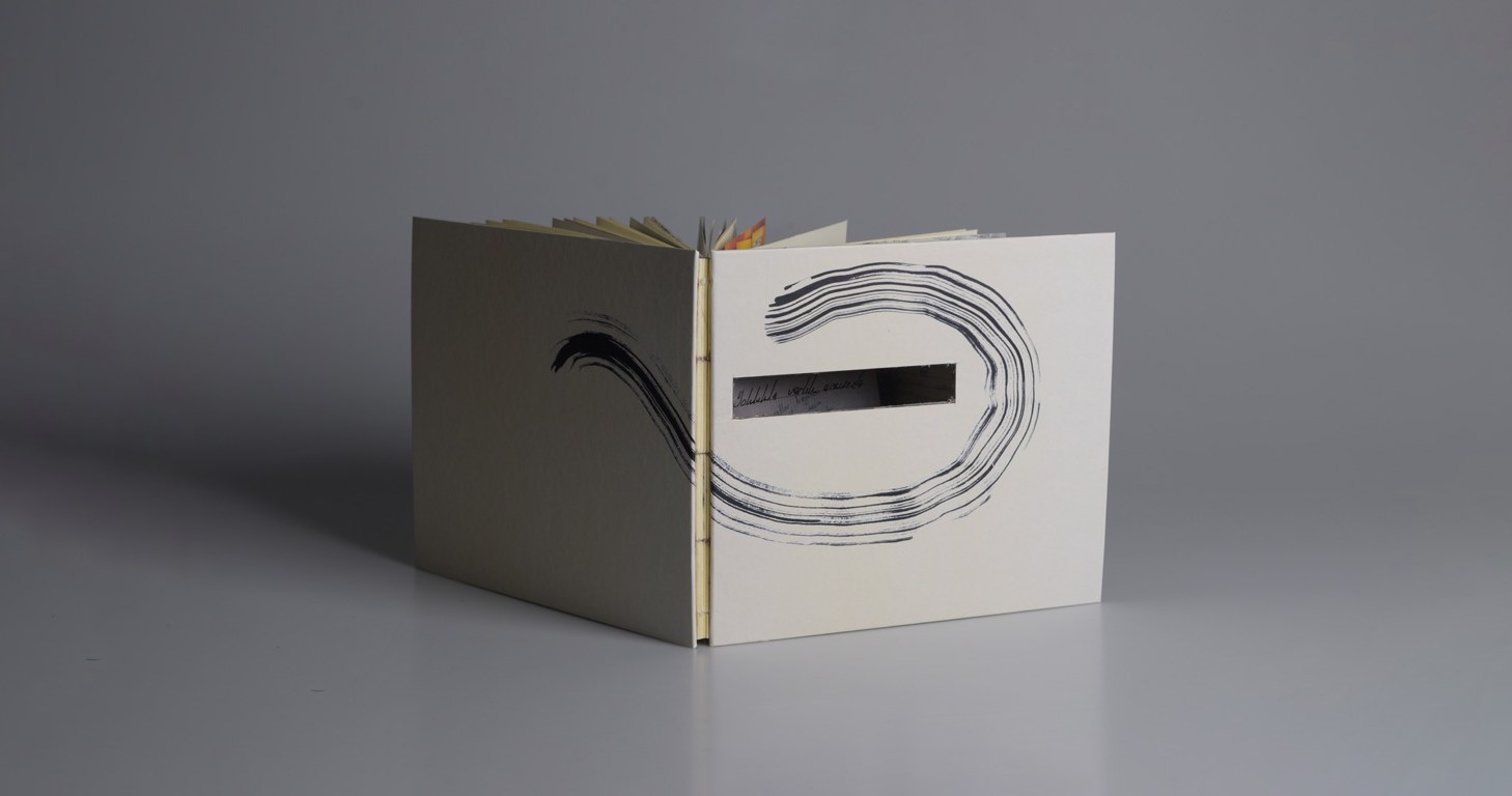 Between Absence and Presence, open book showing the ink spiral and cut-out